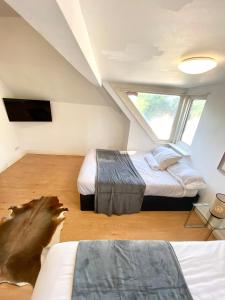伦敦Penthouse studio with 2 double beds & smart TV. Great London Location的阁楼卧室设有两张床和窗户。