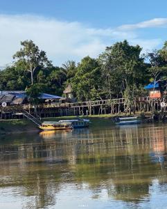 伊基托斯Ceiba Amazon Lodge的两艘船停靠在河上,有一座桥