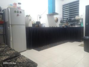 关丹Homestay Izzauni的厨房配有白色冰箱和黑色柜台。