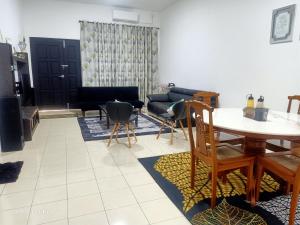 关丹Homestay Izzauni的客厅配有桌子和沙发