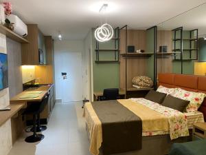 瓜鲁柳斯Studio Patteo Bosque Maia的一间卧室配有一张床、一张桌子和一个水槽