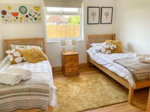 霍尔斯特德Aylesbury Lodge的一间卧室设有两张单人床和一个窗户。
