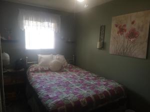 北湾Paradise Inn的一间卧室配有一张带床罩的床和窗户