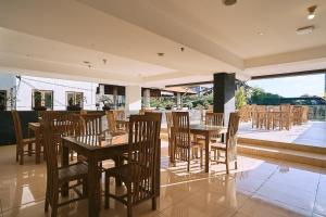 库塔Horison Kuta Bali的一间带木桌和椅子的餐厅以及庭院