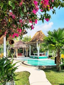 婆罗浮屠嘉怒尔别墅旅馆的一个带凉亭和粉红色鲜花的度假游泳池
