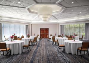 Saint Rose新奥尔良机场智选假日酒店及套房的宴会厅配有桌椅和吊灯