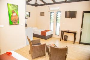 SigatokaSeatiki Resort Fiji On Coast的酒店客房带一张床、一张桌子和椅子
