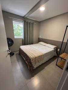 邦比尼亚斯Residencial Tia Dilma的一间卧室设有一张床和一个窗口