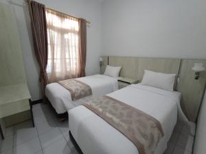 TimuranHASTOSTAY @suryodiningratan的配有窗户的酒店客房内的两张床