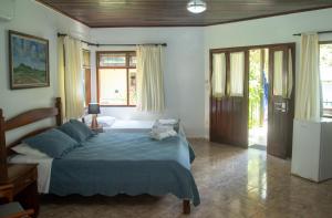 戈亚斯州上帕莱索Pousada Casa Rosa的一间卧室配有一张带蓝色棉被的床