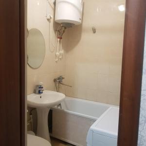 卡拉甘达Однокомнатная квартира в Караганде的浴室配有盥洗盆、卫生间和浴缸。