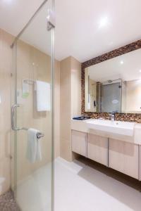 芭堤雅市中心Centara Life Avenue Hotel Pattaya的带淋浴、盥洗盆和镜子的浴室