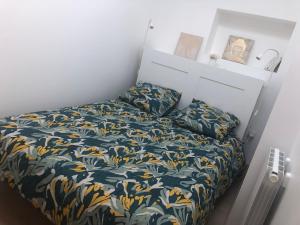 布隆Appartement paisible proche centre ville的小卧室配有一张带花卉床罩的床