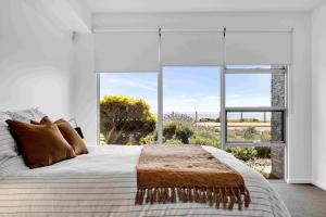 阿丁格海滩180 View by Wine Coast Holiday Rentals的一间卧室设有一张大床和一个大窗户