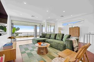 阿丁格海滩180 View by Wine Coast Holiday Rentals的客厅配有绿色沙发和桌子