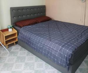 班达拉朗西JATUPORN A2的一间卧室配有一张带蓝色棉被的床