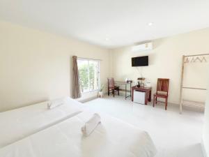 Ban Huai Sua绿色度假村 的一间白色卧室,配有床、书桌和电视