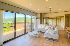 伊豆Izu Serenity Fuji-View Retreat with Private Onsen的带沙发的客厅和阳台