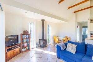 贝拉拉贝拉拉泻湖前小木屋度假屋的客厅配有蓝色的沙发和炉灶。