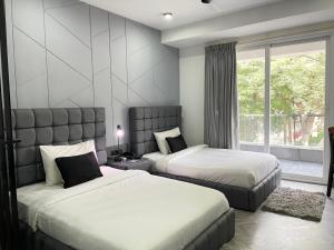 古尔冈BedChambers Luxurious Serviced Apartment in Gurgaon的一间卧室设有两张床和大窗户