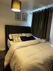 AddingtonLovely room in South London的一间卧室配有一张大床和黑色窗帘
