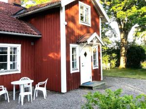 TystbergaHoliday home Tystberga III的红色的房子,有白色的门和桌椅