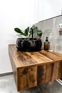百乐费利克斯Ego Apartments的木台上带盆栽的黑色浴室水槽