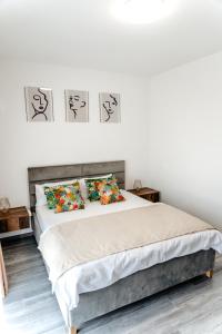 百乐费利克斯Ego Apartments的卧室内的一张床铺,墙上有三幅画