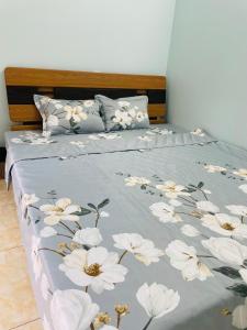 海防GM Homestay的一张床上的蓝色毯子,上面有白色的花朵