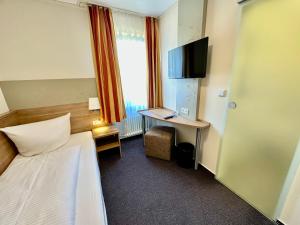 吕德斯海姆科兰切酒店的酒店客房配有一张床和一张书桌及一台电视