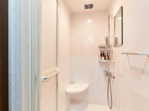 那霸Grand Cabin Hotel Naha Oroku的白色的浴室设有卫生间和淋浴。
