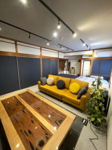 雾岛市Boss'sHouse犬ok天然温泉あり的客厅配有黄色的沙发和床。