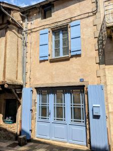 纳雅克Le Quatorze, au cœur de Najac的一座古老的建筑,设有蓝色的门窗