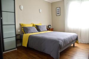 蓬蒂维Le clos argoat的一间卧室配有一张大床,提供黄色和蓝色的枕头