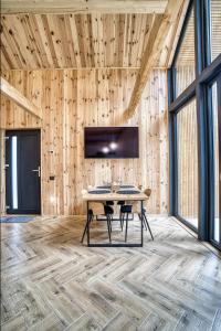 锡纳亚Norway Cabins的木墙上的带桌子和电视的用餐室