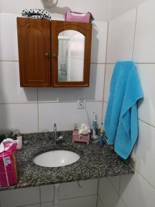 尼泰罗伊Aconchego de Piratininga-Niterói Rj的浴室柜台配有水槽和蓝毛巾