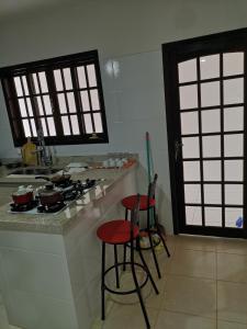 尼泰罗伊Aconchego de Piratininga-Niterói Rj的厨房配有2张凳子和带炉灶的台面