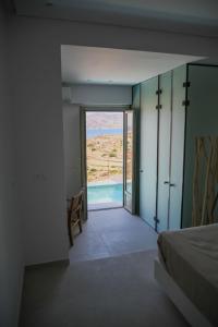 基莫洛斯岛ANEMOLETHE的一间卧室设有通向游泳池的门