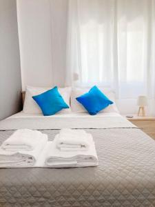 阿莫利亚尼岛Mokamvilia House的一张带蓝色枕头的床和白色毛巾