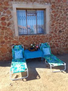 RosslynKGOLA SAFARIS的两把椅子和一张蓝色桌子,位于大楼前