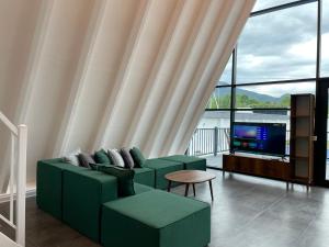 盖贝莱Qafqaz Falcon Chalet的客厅配有绿色沙发和电视