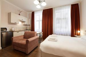 里加Stabu Sēta Apartments的酒店客房带一张床、椅子和厨房