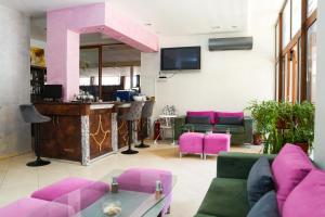 切尔诺莫雷茨Akladi Family Hotel的客厅配有粉色家具和酒吧