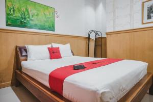 班达楠榜RedDoorz near Kartini Mall Lampung的一间卧室配有一张带红色和白色枕头的大床