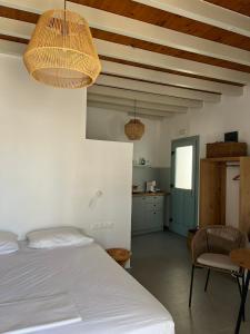 阿斯提帕莱亚镇Arhodiko Studios的一间卧室配有一张床铺和一张桌子,还设有一间厨房