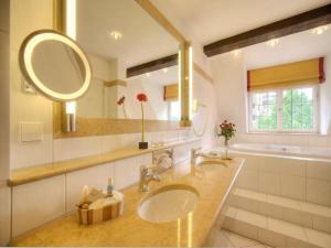 施韦比施哈尔Trip Inn Hotel Der Adelshof的一间带两个盥洗盆和大镜子的浴室