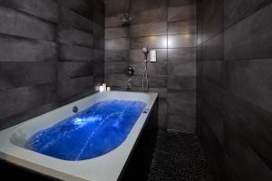 里加Stabu Sēta Apartments的设有带大型蓝色浴缸的浴室