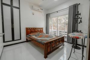 拜蒂克洛Sri Construction Circuit Bungalow的一间卧室设有一张床和一个大窗户