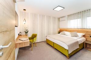 Feldkirchen bei GrazMedirooms Apartments的一间卧室配有一张床、一张桌子和一把椅子