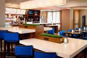 埃尔金Sonesta Select Chicago Elgin West Dundee的餐厅设有白色的桌子和蓝色的椅子